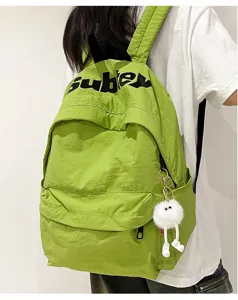 Zaino scolastico verde in tela da donna e studenti con simpatico ciondolo di peluche.