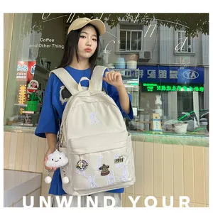 Casual canvas backpack with letter patches, large capacity student school bag for daily travel.