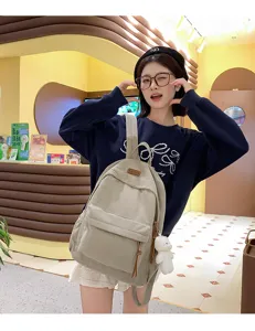 Casual corduroy backpack for women, trendy school bag with cute bear pendant for daily travel.