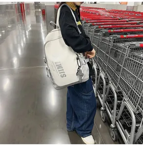 Detailed view of large capacity casual backpack worn by model in a retail store aisle.