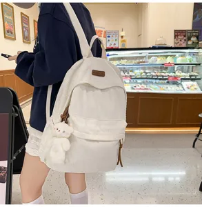 Large capacity white corduroy backpack for women, stylish school bag with bear pendant.