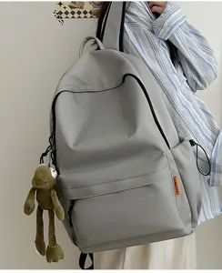 Minimalist grey backpack with cute frog pendant, large capacity school book bag for daily use.
