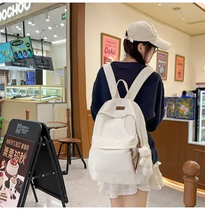 Casual corduroy backpack with cute pendant, fashionable school bag for daily use.