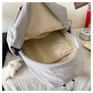 Large capacity grey casual backpack for students and daily commuting with cute bear pendant.