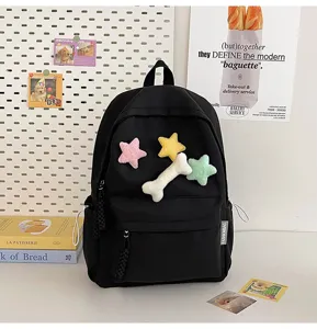 Minimalist black student school backpack with cute plush star and bone decorations for daily use.