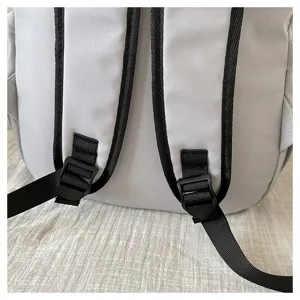 Close-up detail of grey casual backpack shoulder straps and adjustable plastic buckles.