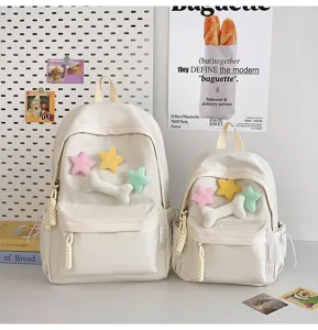 Detailed view of minimal aesthetic beige school backpacks with cute plush star and bone charms.