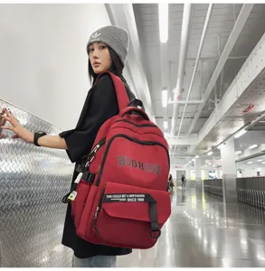 Detailed view of the large capacity red retro student backpack with multiple practical pockets.