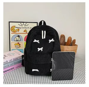 Detailed view of the black corduroy school backpack featuring cute white bow accents in setup.