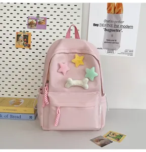 Pink student backpack with cute plush stars and bone decor, casual ins style school bag.