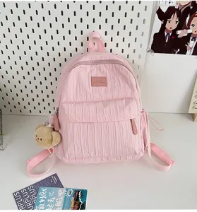 Solid pink pleated backpack with cute bear pendant, lightweight casual school bag for daily travel.