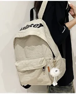 Vista dettagliata dello zaino beige in stile giapponese con ciondolo peluche alla moda.