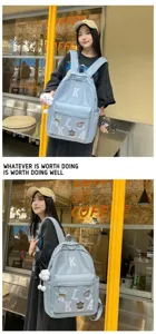 Detailed view of casual blue canvas backpack with letter patches and large capacity for students.