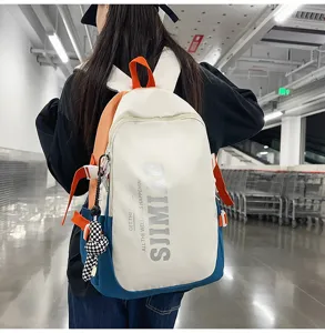 Detail view of the multi-pocket color block casual backpack showing the zipper and straps.