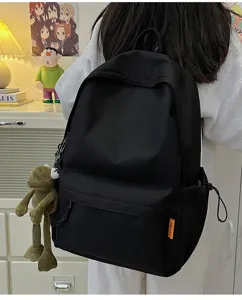 Detail view of a minimalist solid color canvas backpack with side pockets and doll.