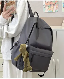 Detail shot of the large capacity dark grey minimalist backpack with a cute frog plush pendant.