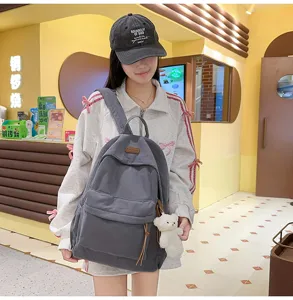 Grey corduroy backpack with cute bear pendant, large capacity casual school bag for daily use.