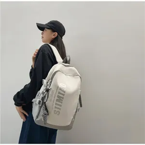 Close-up detail of stylish large-capacity canvas backpack with modern letter print design.