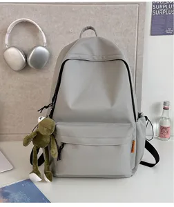Grey minimalist casual backpack detail view, large capacity school bag with front pocket design.