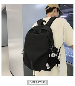 Casual black canvas backpack with heart front pocket and cute plush monkey keychain.