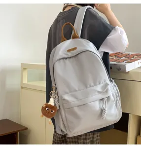 Korean style high school backpack casual daypack with cute plush pendant for women and students.