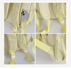 Detailed view of light yellow backpack shoulder strap, zipper pocket and white buckle closeup.