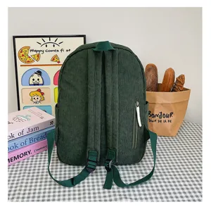 Dark green corduroy backpack detail view, stylish casual student school bag with side zipper.