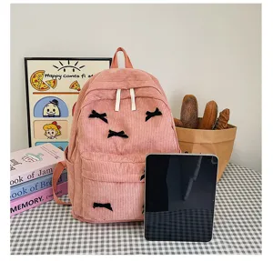 Pink corduroy backpack detail view, sweet bow design school bag for daily fashion and students.
