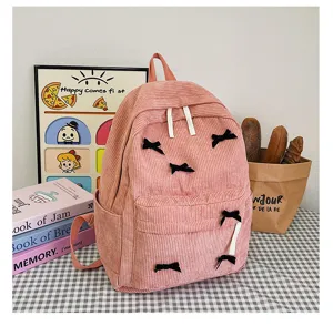 Detailed view of the Japanese style pink corduroy backpack featuring sweet black bowknot details.