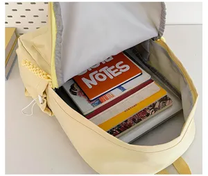 Detailed view of the large capacity interior of the bright yellow student backpack with books.