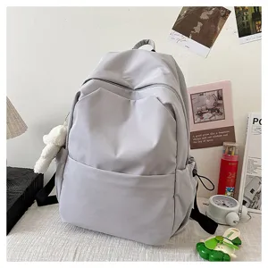 Grey minimalist casual backpack detail view, large capacity school bag with plush bear pendant.
