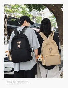 Detailed view of campus casual backpack with large capacity and cute plush pendant for daily use.