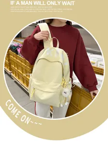 Detail view of a casual yellow canvas backpack with multiple pockets and daily wear design.