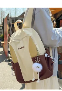 Stylish canvas backpack in cream and brown with cute plush charm for daily school use.