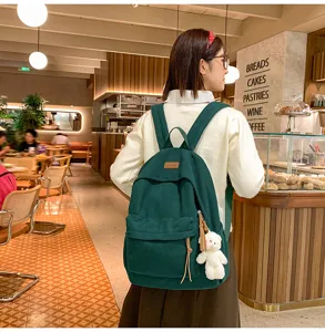 Green corduroy backpack for women students with cute bear pendant, large capacity casual bag.