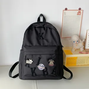 Classic minimalist black backpack for school and travel with chic letter embroidery and patches.