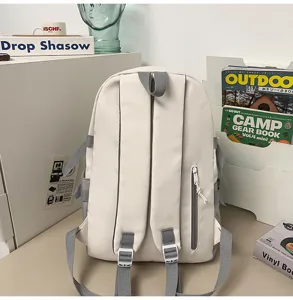 Minimalist white student backpack with grey straps, ideal for daily school and laptop carry.