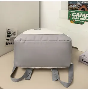 Detailed view of large capacity grey and white canvas school backpack, durable straps and design.