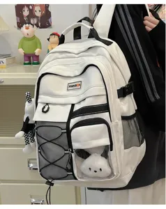Close-up detail of white tactical school backpack with multiple pockets, mesh, and straps.