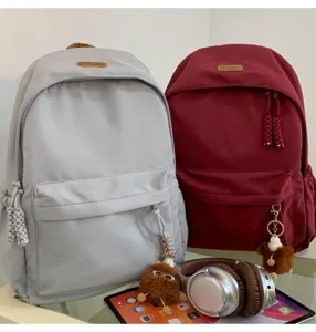 Detail showcase of Korean style casual school backpack in grey red with cute plush charm.