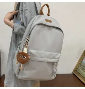 Casual grey nylon backpack for student daily use, trendy school bag with plush pendant.