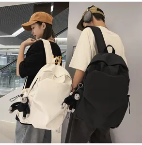 Detailed view of stylish minimalist campus backpack in black and white with cute monkey pendant.