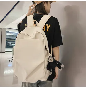 Large capacity minimalist canvas backpack beige school bag with cute monkey pendant.