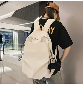Minimalist large capacity beige backpack with cute monkey pendant for college students daily use.