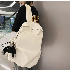 Detail shot of the minimalist canvas backpack in cream white with a cute pendant.