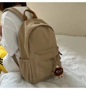 Casual khaki backpack for students, stylish daily school bag with cute fluffy plush keychain.