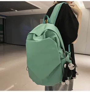 Minimalist daily canvas backpack with cute monkey charm, large capacity school bag for students.