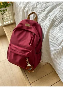 Korean style minimalist wine red backpack student school bag with cute pendant and pocket.