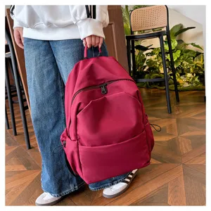 Red casual backpack detail, large capacity design with durable fabric and practical zip pockets.
