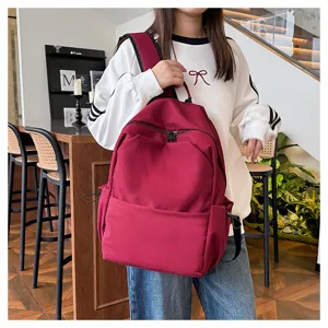 Detail view of the large capacity solid color casual backpack in wine red for daily use.